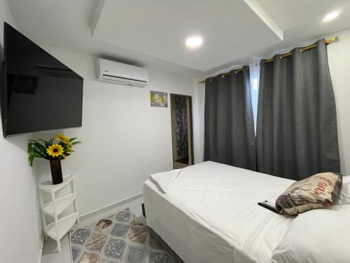 a bedroom with a bed and a flat screen tv at Hotel Boutique Al-Basit in Cartagena de Indias