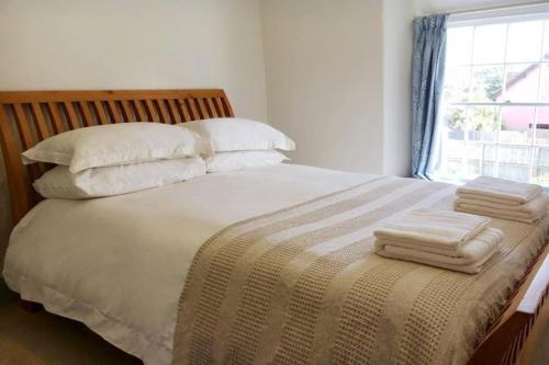 a bedroom with a bed with pillows and a window at Travershes Holiday Cottage in Exmouth