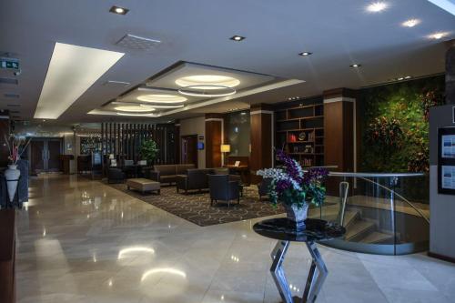 un vestíbulo con un jarrón de flores sobre una mesa en Best Western Premier Karsiyaka Convention & Spa Hotel, en Izmir
