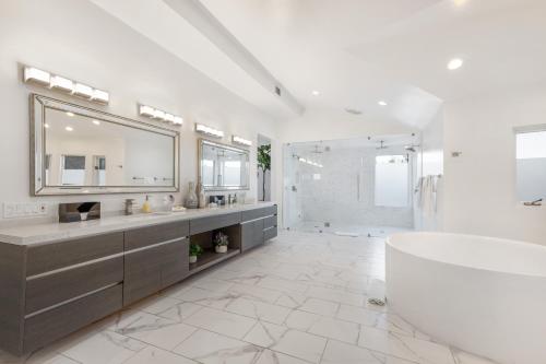 a bathroom with a tub and a sink and a mirror at Anzio Estate in Los Angeles