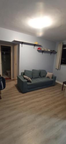 un soggiorno con divano blu in una camera di Apartamento em Lauro de Freitas com tudo a Lauro de Freitas