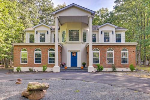 a large brick house with a blue door at Deck and Fire Pits Immaculate Poconos Lodge! in Albrightsville