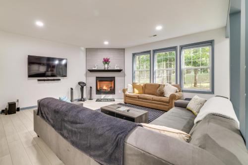 a living room with a couch and a fireplace at Deck and Fire Pits Immaculate Poconos Lodge! in Albrightsville