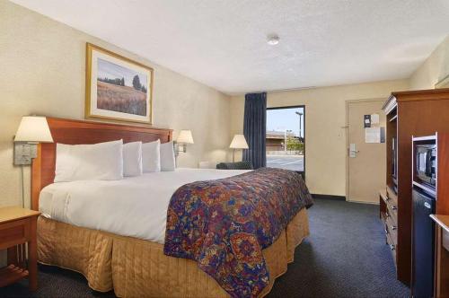 a hotel room with a large bed and a window at Baymont by Wyndham Macon I-75 in Macon