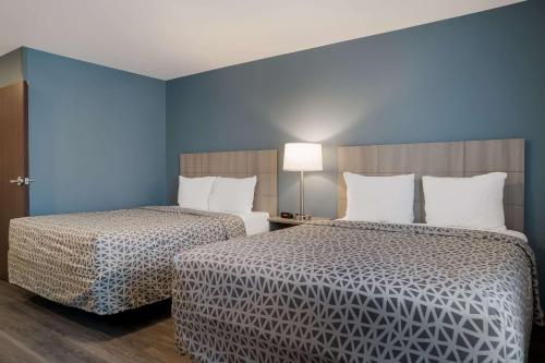 Duas camas num quarto com paredes azuis em WoodSpring Suites Detroit Sterling Heights em Sterling Heights