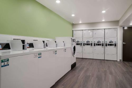 a laundry room with washing machines and lockers at WoodSpring Suites Detroit Sterling Heights in Sterling Heights