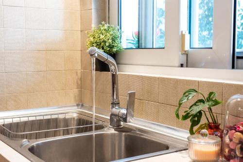 a sink with a faucet in a kitchen at Emma's Airport Studio in Spáta