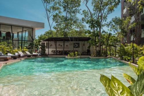 einem Pool mit blauem Wasser vor einem Gebäude in der Unterkunft Jade Tulum Zen Residences - Premium XL Apartment in Tulum