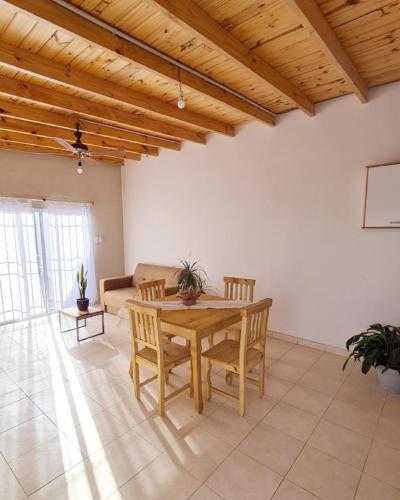 sala de estar con mesa de madera y sillas en Casa Nuup en Río Tercero