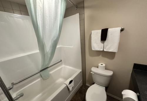 La salle de bains est pourvue d'une baignoire, de toilettes et de serviettes. dans l'établissement Voyageur Motel, à Rocky Mountain House