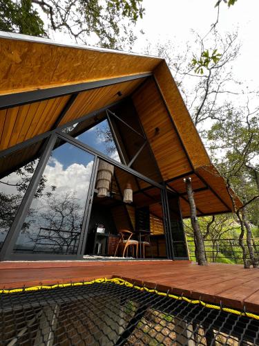a house with large glass windows and a wooden deck at Woodland Cabins in Santa Ana Jilotzingo