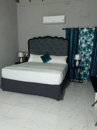 a bed with a black headboard in a bedroom at Oak Villa Montego Bay2 King Room in Montego Bay