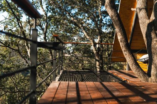 a tree house with a deck in the woods at Woodland Cabins in Santa Ana Jilotzingo