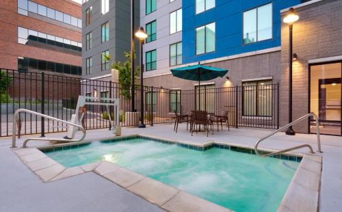 a swimming pool in a building with a table and umbrella at Hyatt Place Provo in Provo