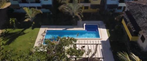 una vista aérea de una piscina en una casa en Apartamento em Ilhéus Pé na Areia en Ilhéus