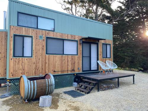 a tiny house with a picnic table and a barrel at Little Pardalote Tiny Home Bruny Island in Alonnah