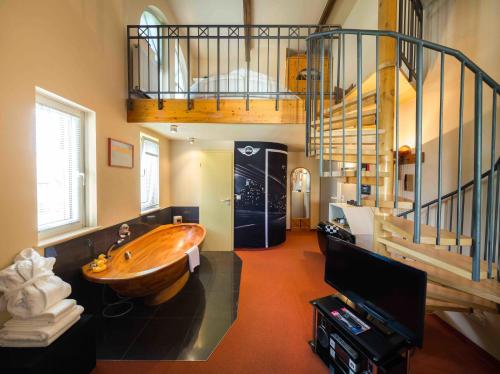 a bathroom with a wooden tub in the middle of a room at Hotel Schindlerhof in Nürnberg