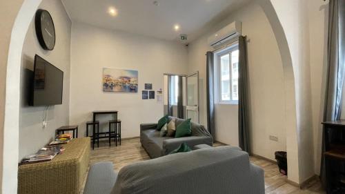 ein Wohnzimmer mit einem Sofa und einem Tisch in der Unterkunft Bookarest Hostel Malta in St Julian's