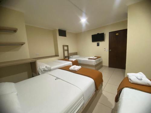 a hotel room with two beds and a television at Hotel Ruiseñor Itagui in Itagüí