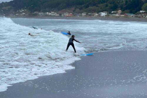 a man riding a wave on a surfboard in the ocean at Duerme y despierta en el Mar in Curanipe