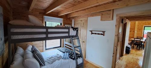a bedroom with a bunk bed in a log cabin at Lochaber Homesteader Lodge in Antigonish