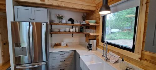 cocina con nevera de acero inoxidable y ventana en Lochaber Homesteader Lodge, en Antigonish
