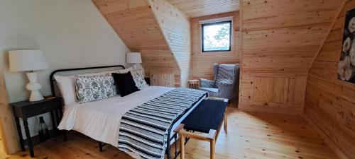 een slaapkamer met een bed, een stoel en een raam bij Lochaber Homesteader Lodge in Antigonish