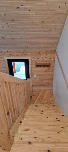 a small wooden room with a window and a staircase at Lochaber Homesteader Lodge in Antigonish