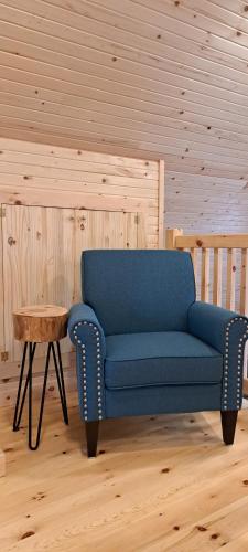 a blue couch in a room with a table at Lochaber Homesteader Lodge in Antigonish