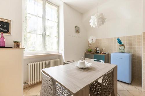 a kitchen with a table and a blue refrigerator at Piccola Venezia - Borgo Valsugana in Borgo