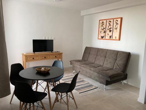 a living room with a couch and a table and chairs at Apartamento céntrico en Mercedes Uruguay in Mercedes