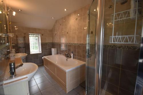 uma casa de banho com 2 lavatórios e um chuveiro em Rural Retreat w/ Hot Tub & River, Sleeps 12 Guests em Tenbury