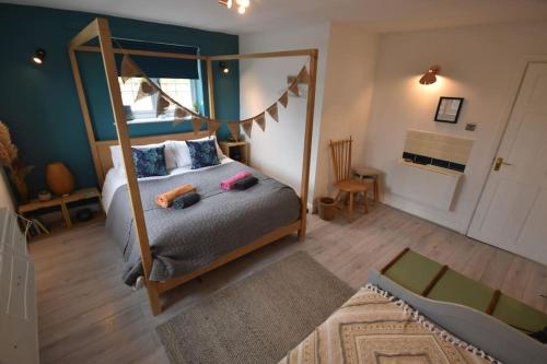 - une chambre avec un lit à baldaquin et un grand miroir dans l'établissement Rural Retreat w/ Hot Tub & River, Sleeps 12 Guests, à Tenbury Wells