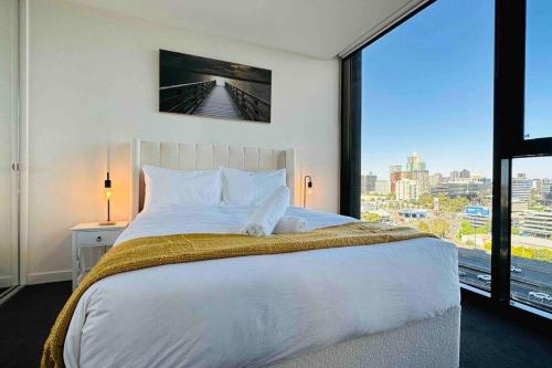 a bedroom with a large bed with a large window at Luxury Condo w/ Ocean View, Pool, Gym near Crown in Melbourne
