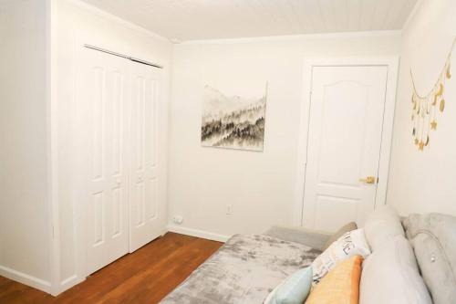 a white living room with a couch and a door at Little Elves Overlook in Sparta