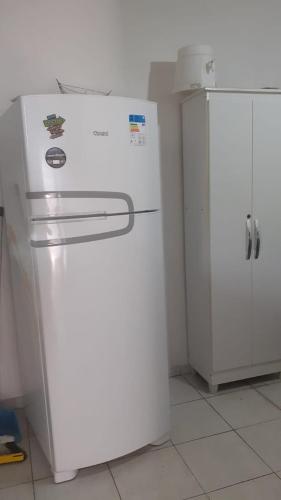 um frigorífico branco ao lado de um armário branco numa cozinha em Lar sossego em Itabuna