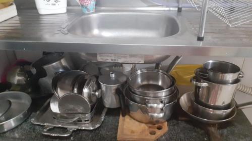 a bunch of pots and pans sitting under a kitchen sink at Lar sossego in Itabuna
