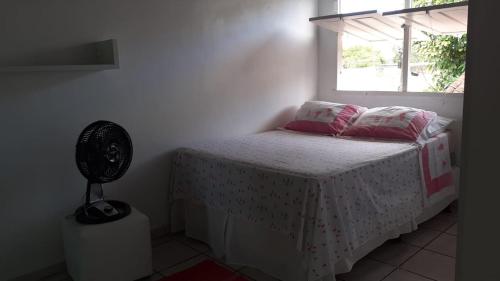 a bedroom with a bed and a window and a fan at Lar sossego in Itabuna