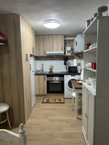una pequeña cocina con electrodomésticos blancos y una mesa en Casa Rural La Simona, en Belmonte