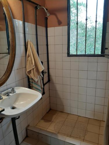 uma casa de banho com um lavatório e um espelho em Delta Rose Farm em Tigre
