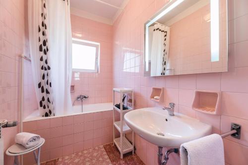 a pink bathroom with a sink and a tub at Apartments in Crikvenica 41682 in Crikvenica