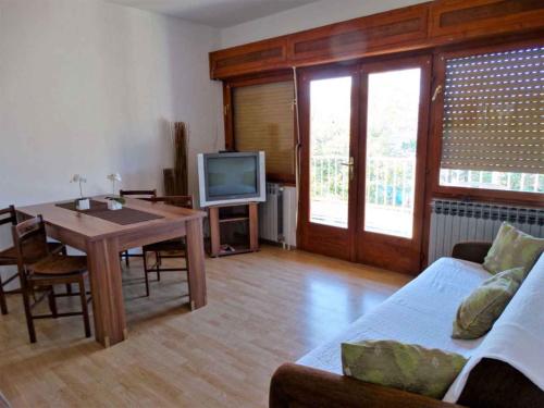 a living room with a table and a tv at Apartments in Crikvenica 41681 in Crikvenica