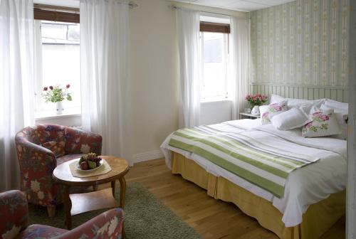 a bedroom with a bed and a chair and a table at Hotell Blå Blom in Gustavsberg