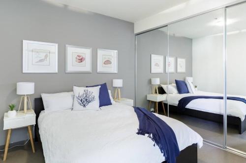 a bedroom with two beds and a mirror at Inspiration Station - An Iconic Designer Pad in Melbourne