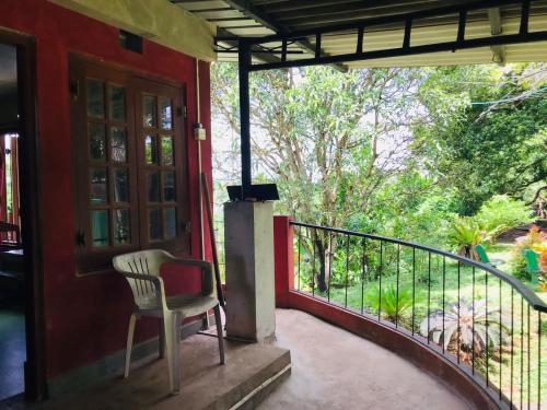 une chaise assise sur la terrasse couverte d'une maison dans l'établissement Coca Cola Hostel Malabe, à Malabe