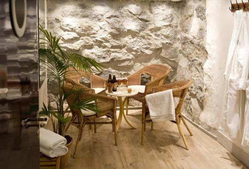 a table and chairs in a room with a stone wall at Hotell Blå Blom in Gustavsberg
