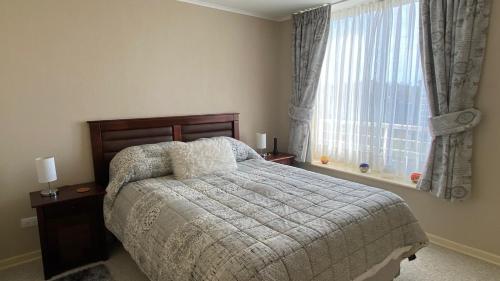 1 dormitorio con cama y ventana en Departamento laguna bahía sol, en Algarrobo