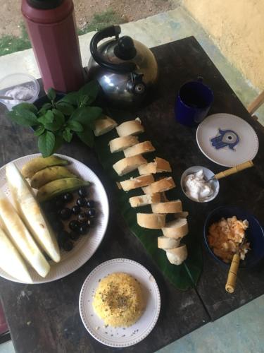 einen Tisch mit verschiedenen Lebensmitteln auf Platten in der Unterkunft Camping Vida Longa in Angra dos Reis