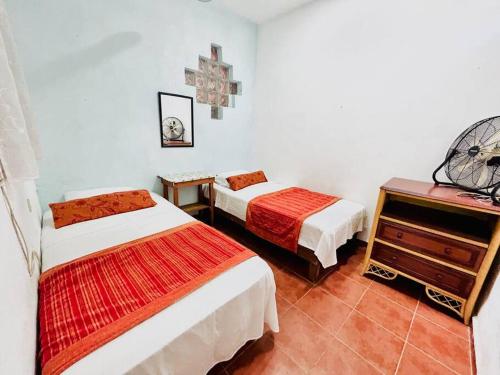 Cette chambre comprend 2 lits et une commode. dans l'établissement Villa Los Duendes, à Cancún