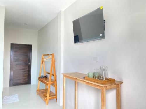a room with a table and a television on a wall at De Saran Lanta in Ko Lanta